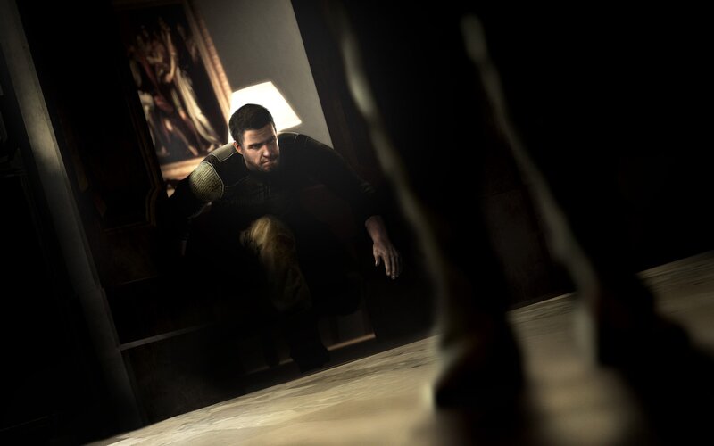 man crouching in dark room