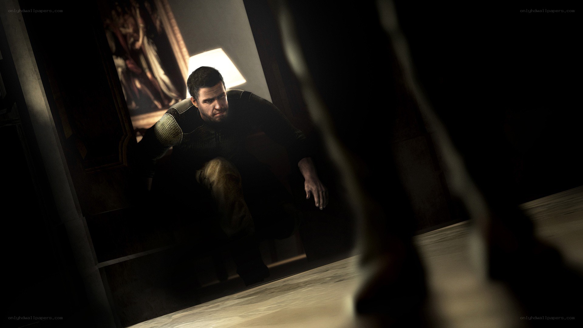 man crouching in dark room