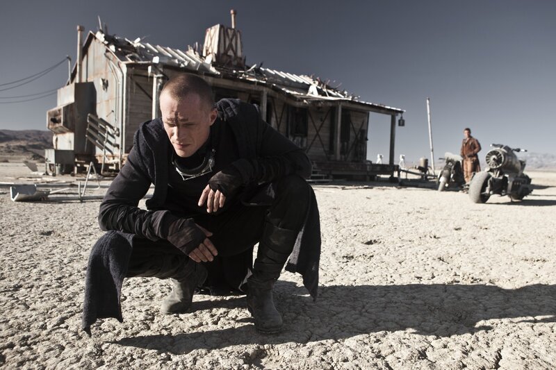 man crouching in desert wasteland