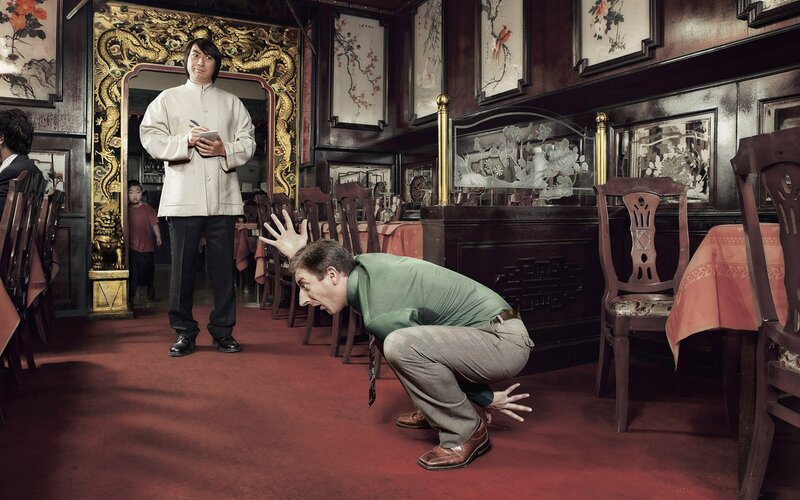 Man crouching in restaurant
