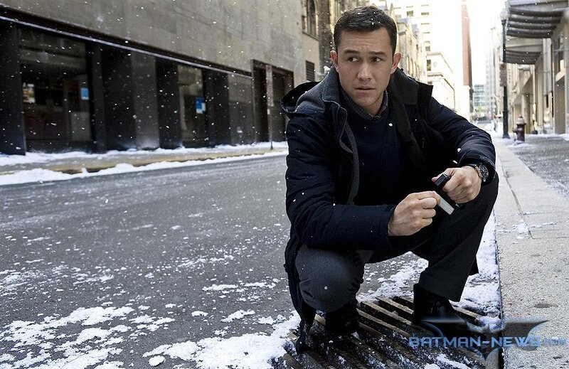 man crouching on snowy street