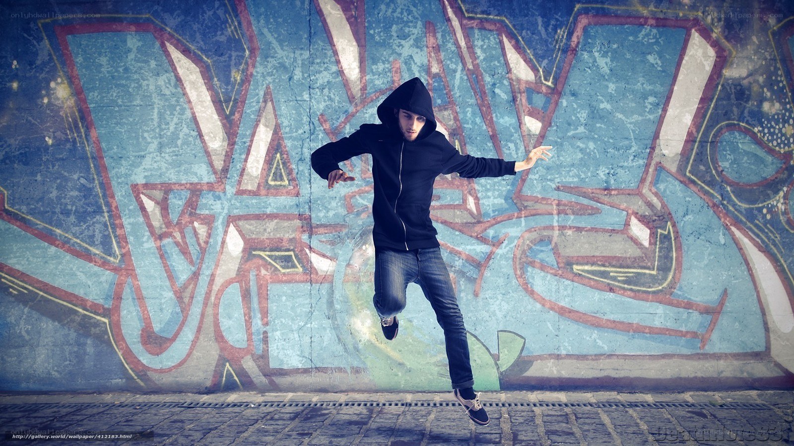 Man dancing in front of graffiti