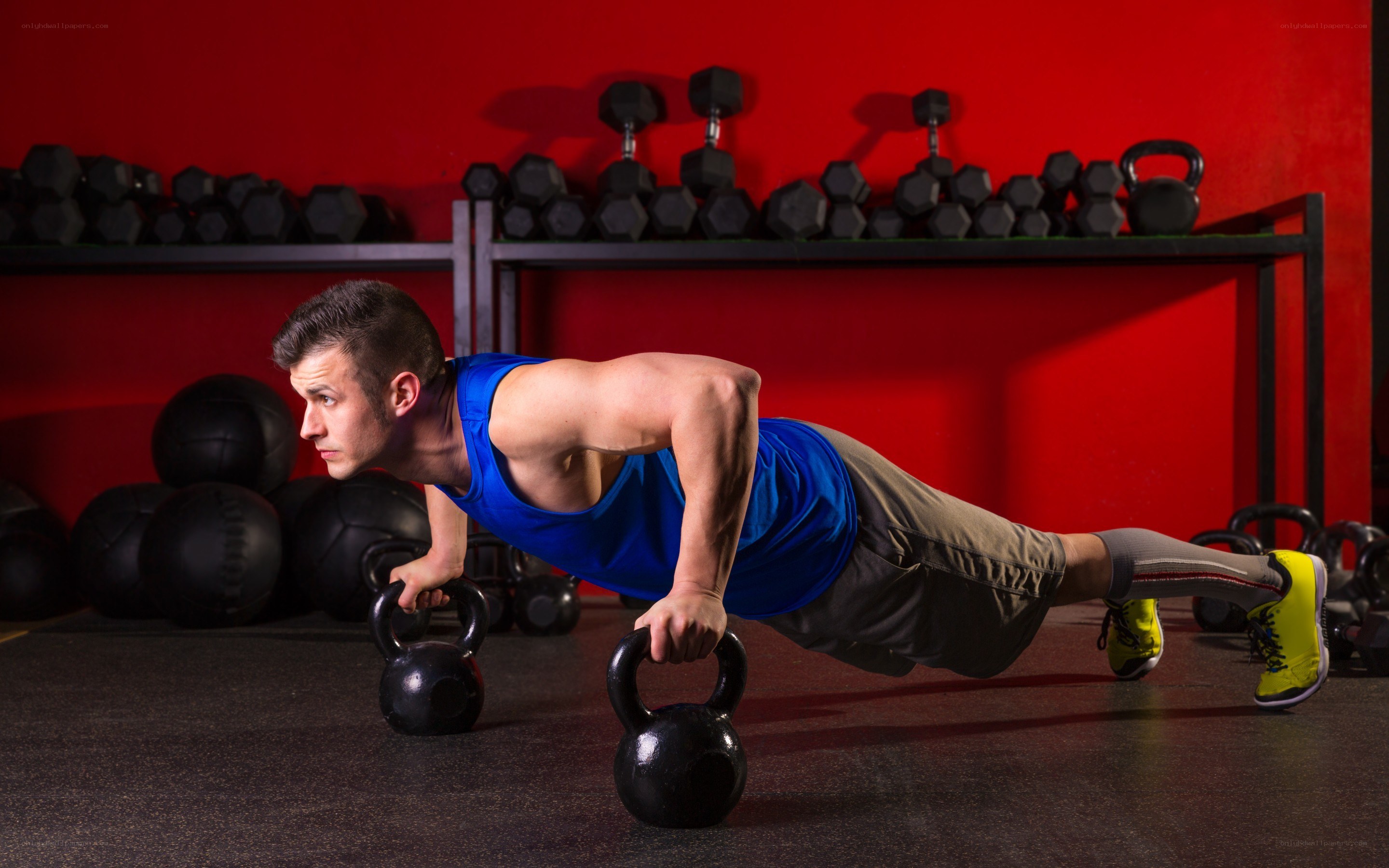 man doing push-ups with kettlebells