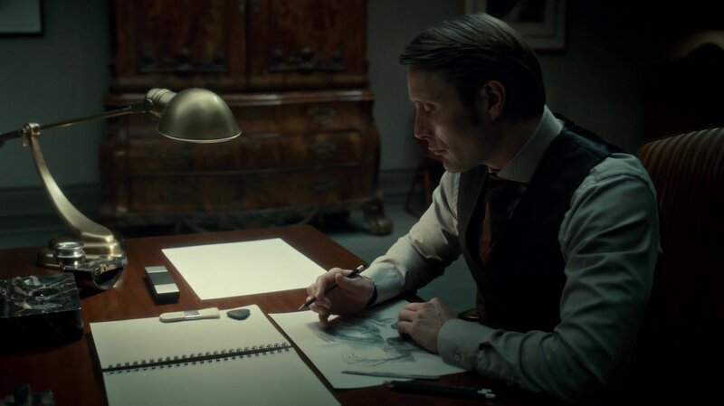 man drawing at a desk