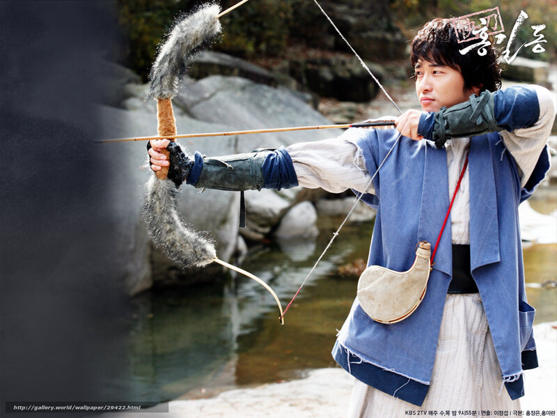 man drawing bow in traditional attire