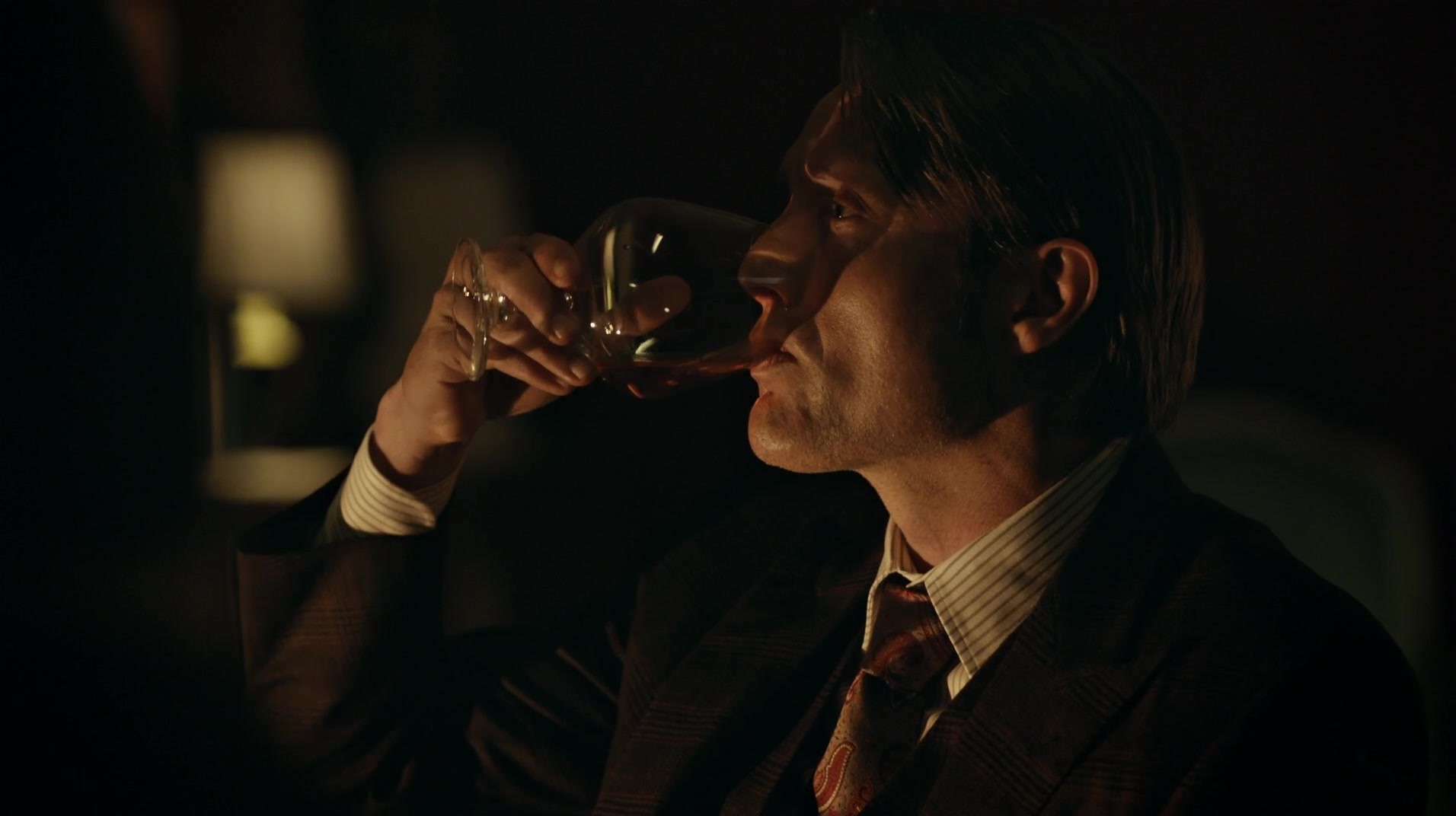man drinking wine in dark room