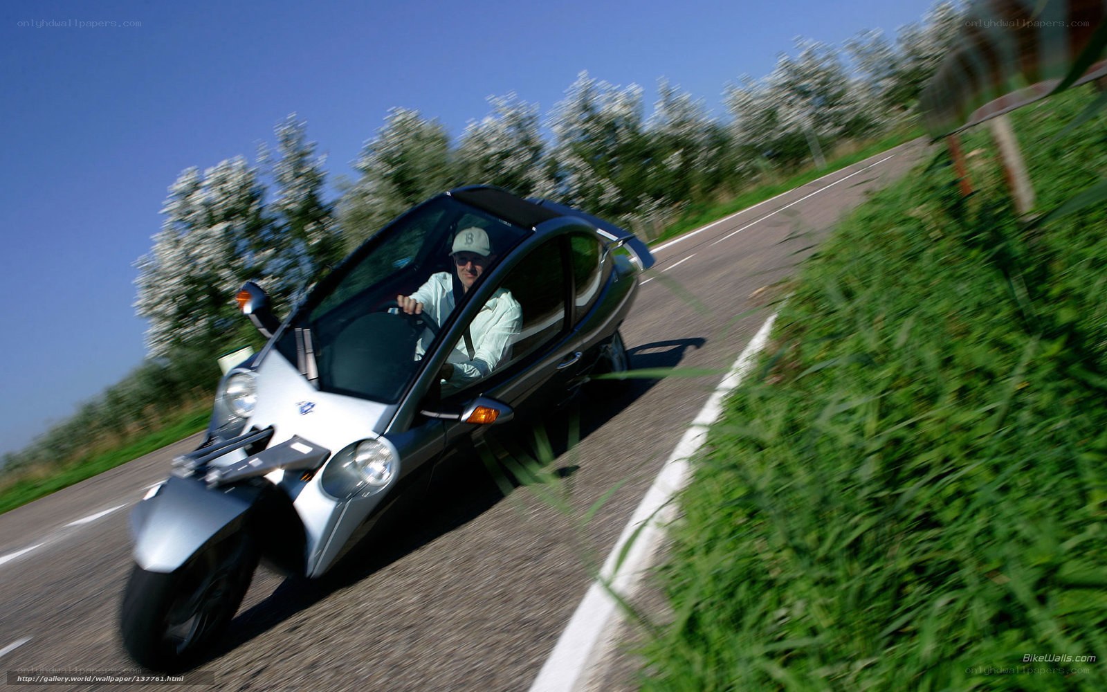 man driving a three-wheeled car