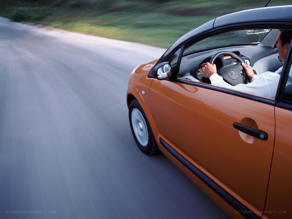 Man driving orange car on road