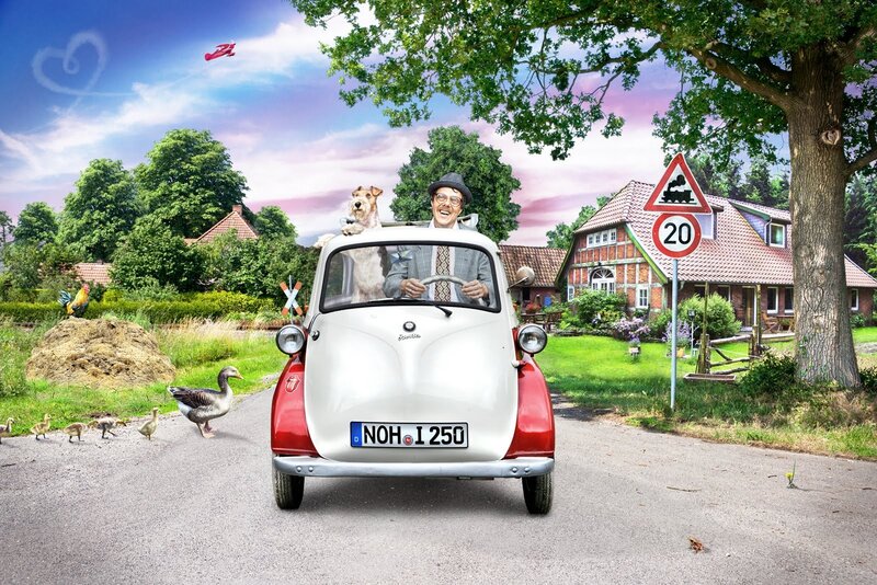 Man driving vintage car with dog