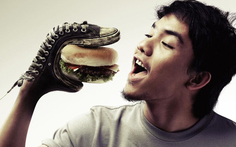 man eating burger from shoe