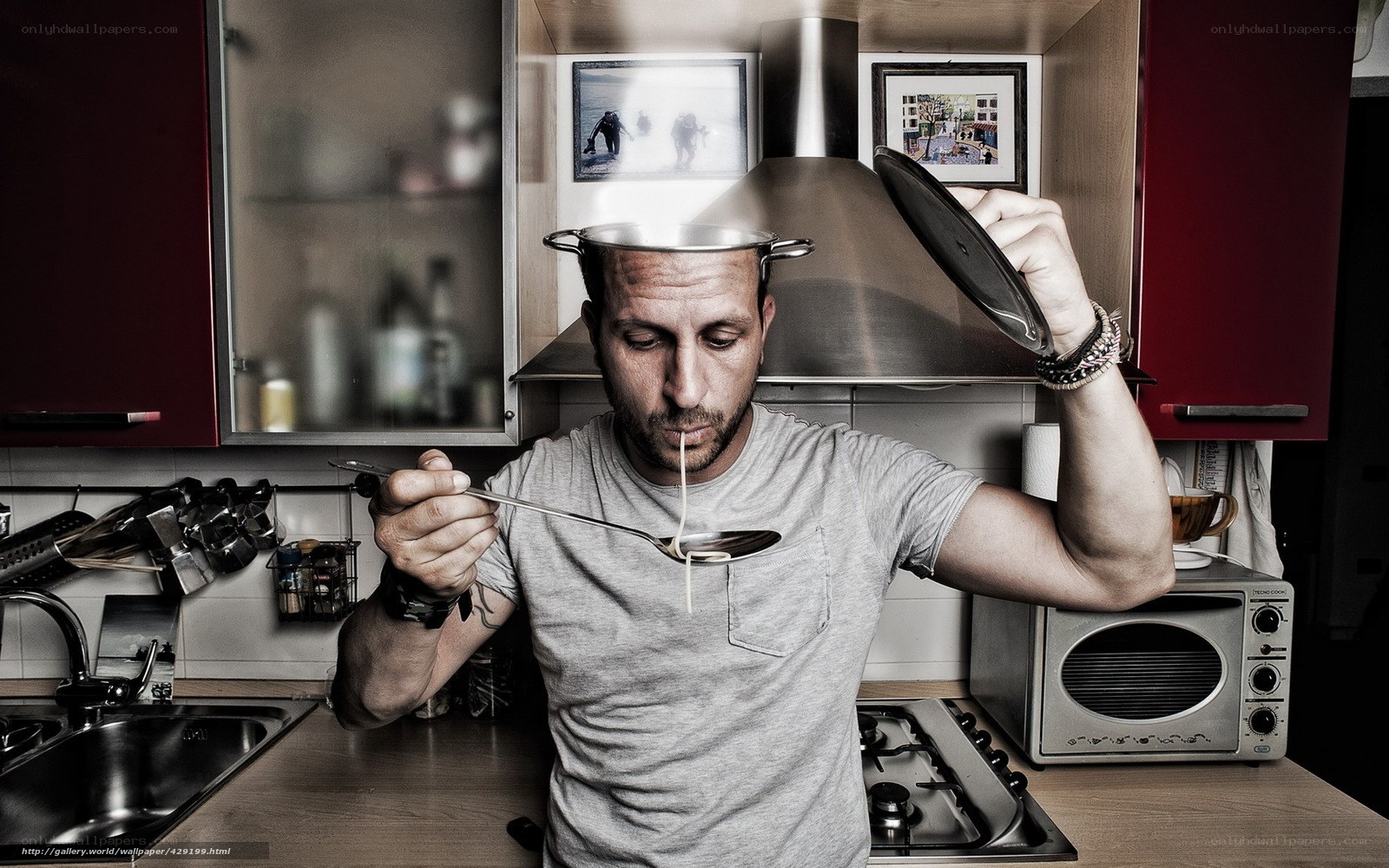 man eating spaghetti in kitchen
