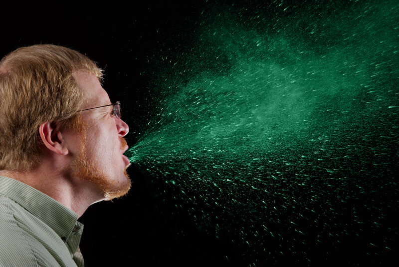 man exhaling green mist