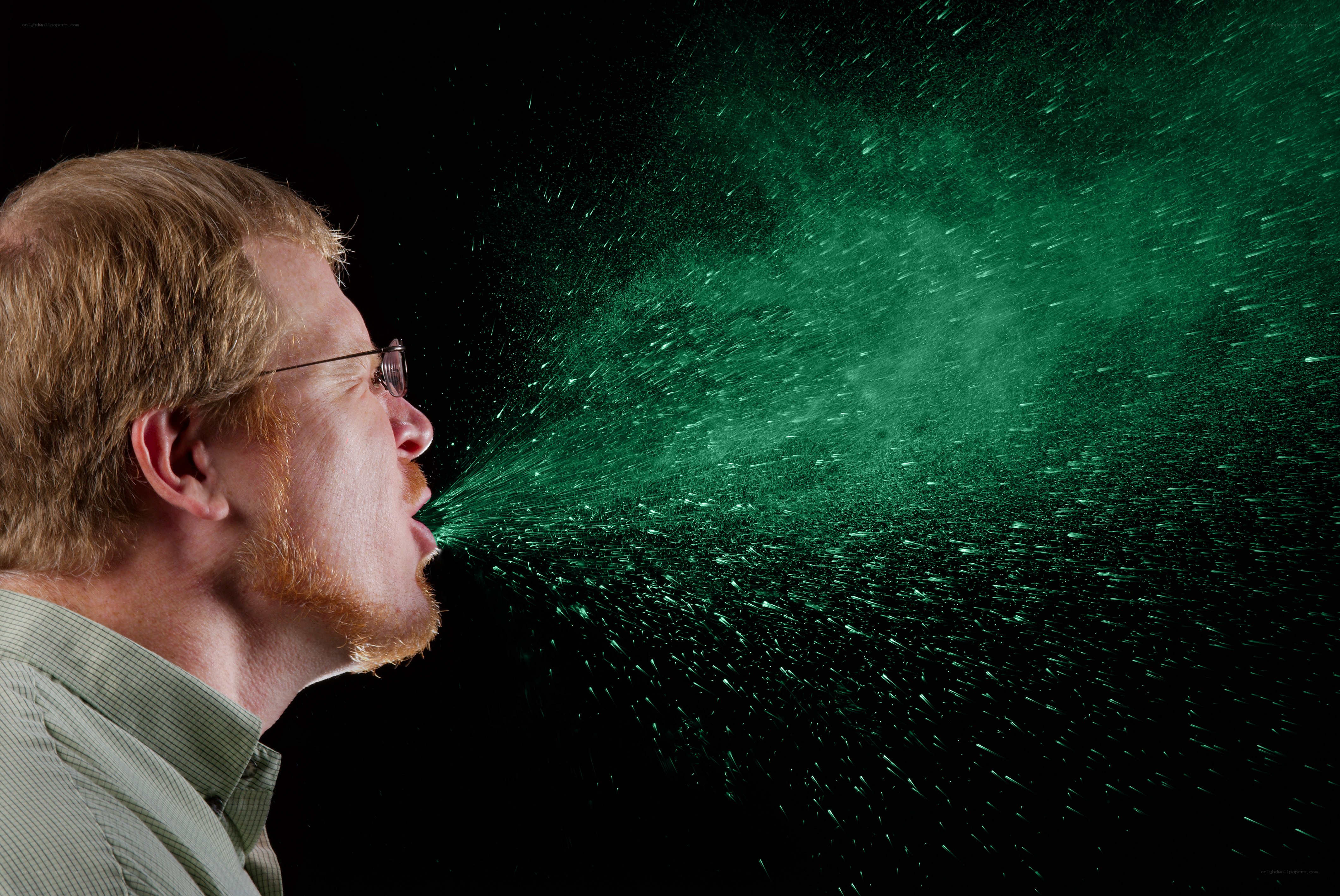 man exhaling green mist