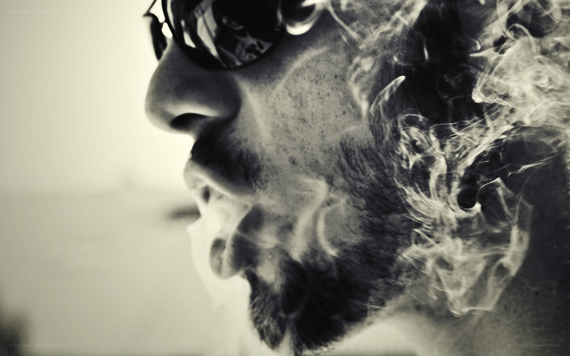 man exhaling smoke in profile