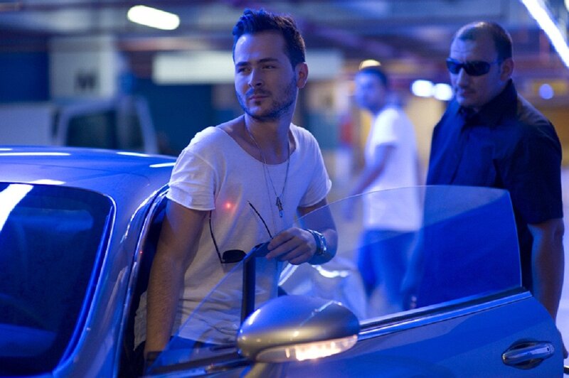 Man exiting blue car in parking garage