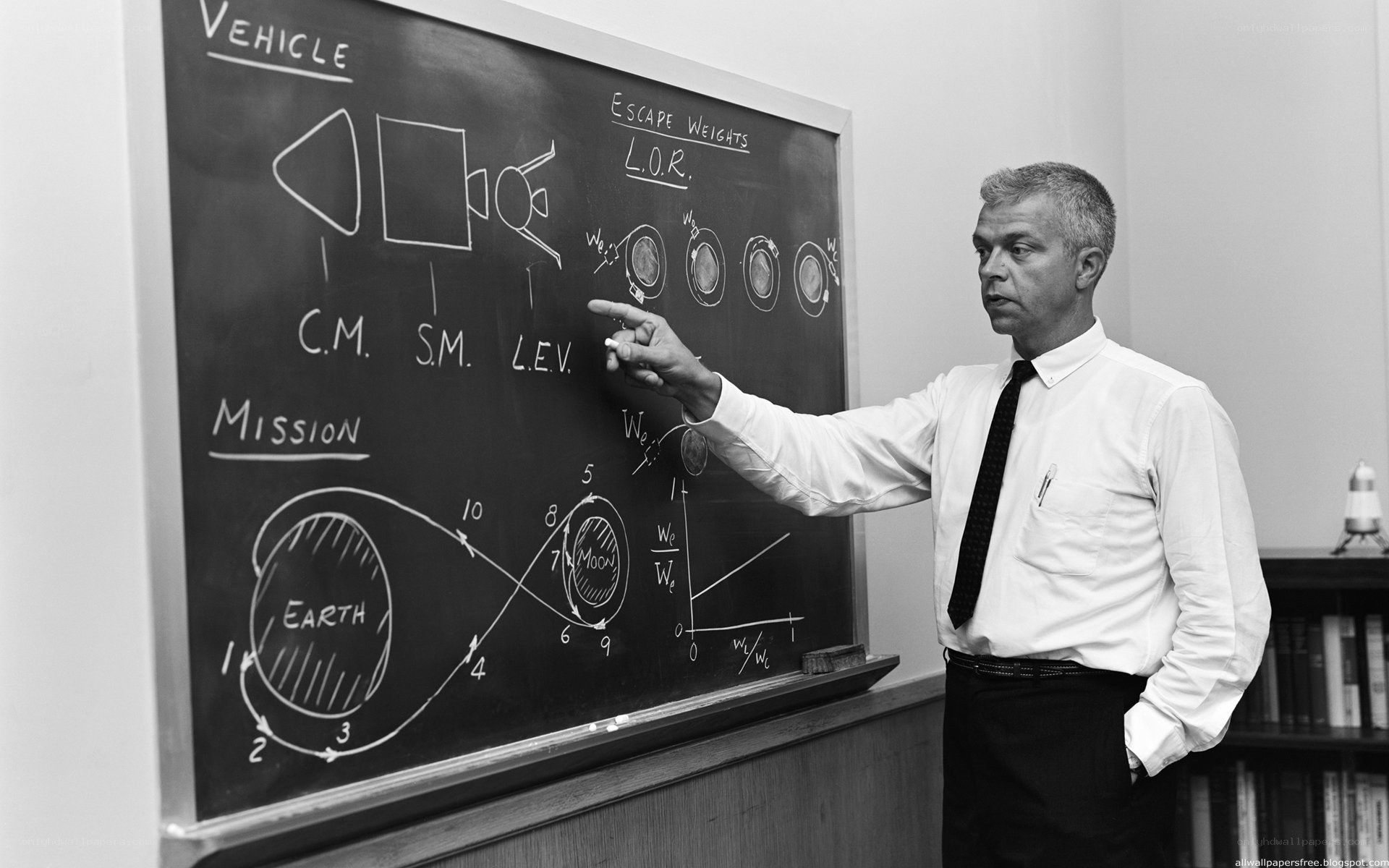 Man explaining space mission on chalkboard
