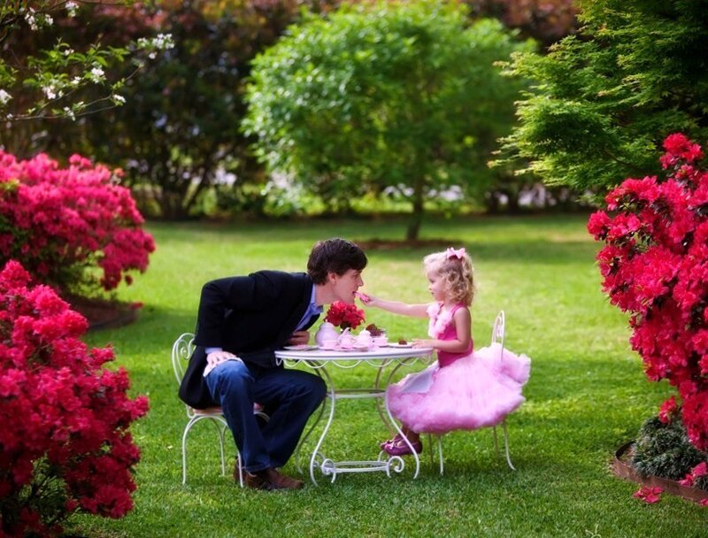 Man feeding girl in garden