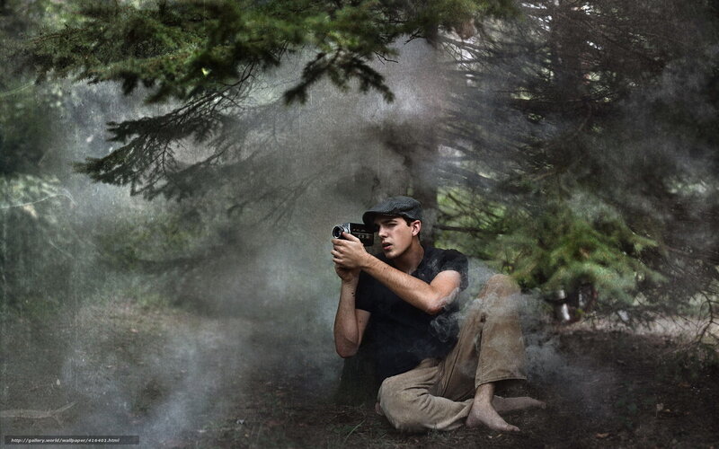 Man filming in forest mist