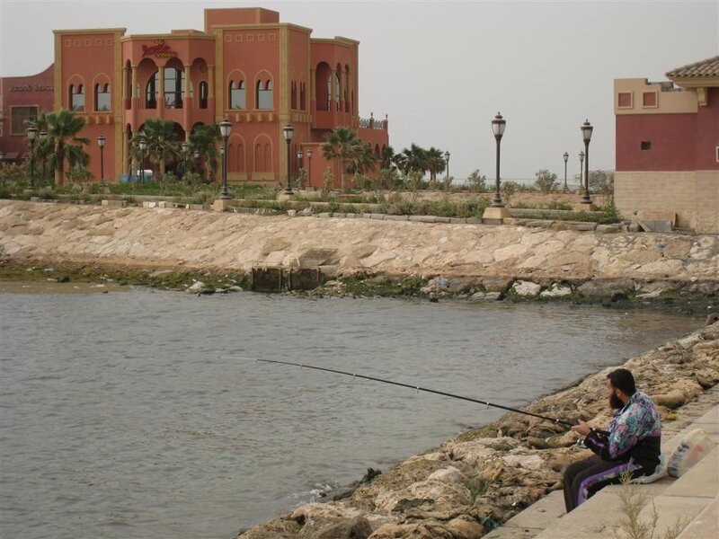 Man fishing by waterfront