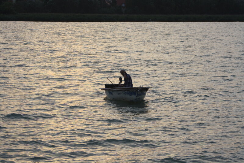 Man Fishing in a Boat — Blue