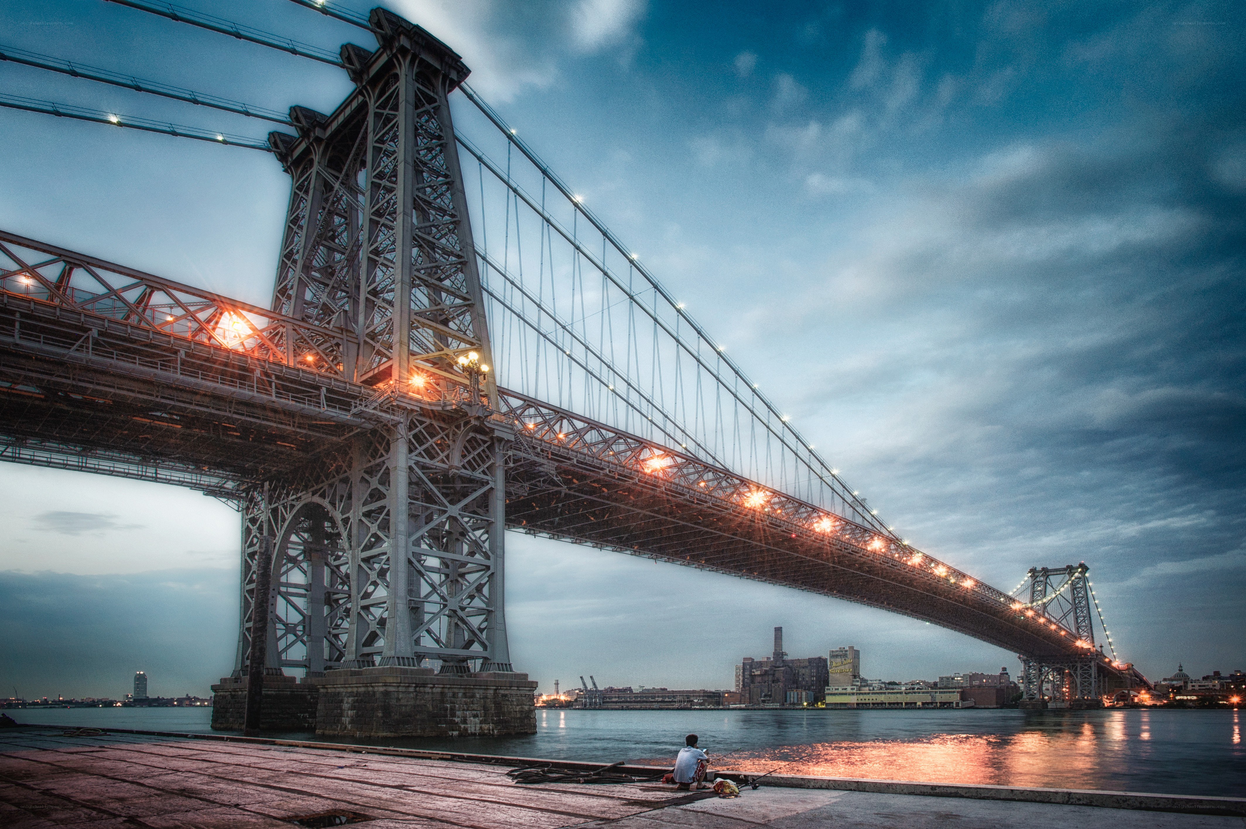 Man fishing under a bridge