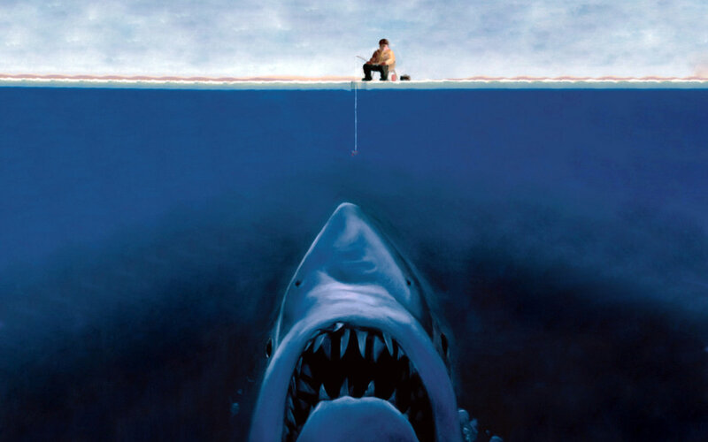 Man fishing with shark below