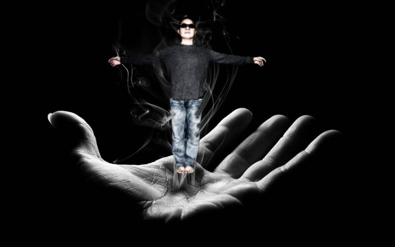 man floating above a hand