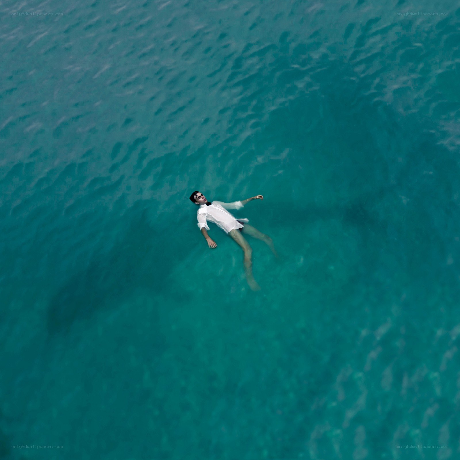 man floating in turquoise water