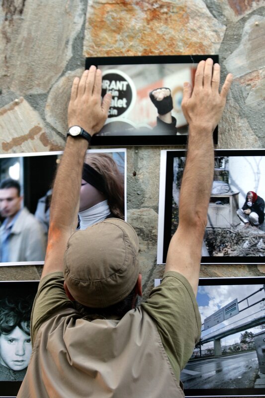 man hanging photos on wall