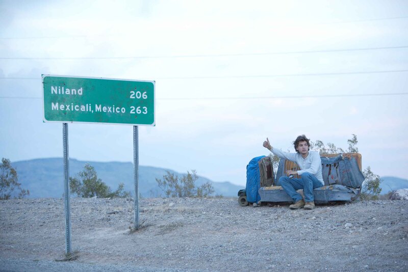 Man hitchhiking on desert road