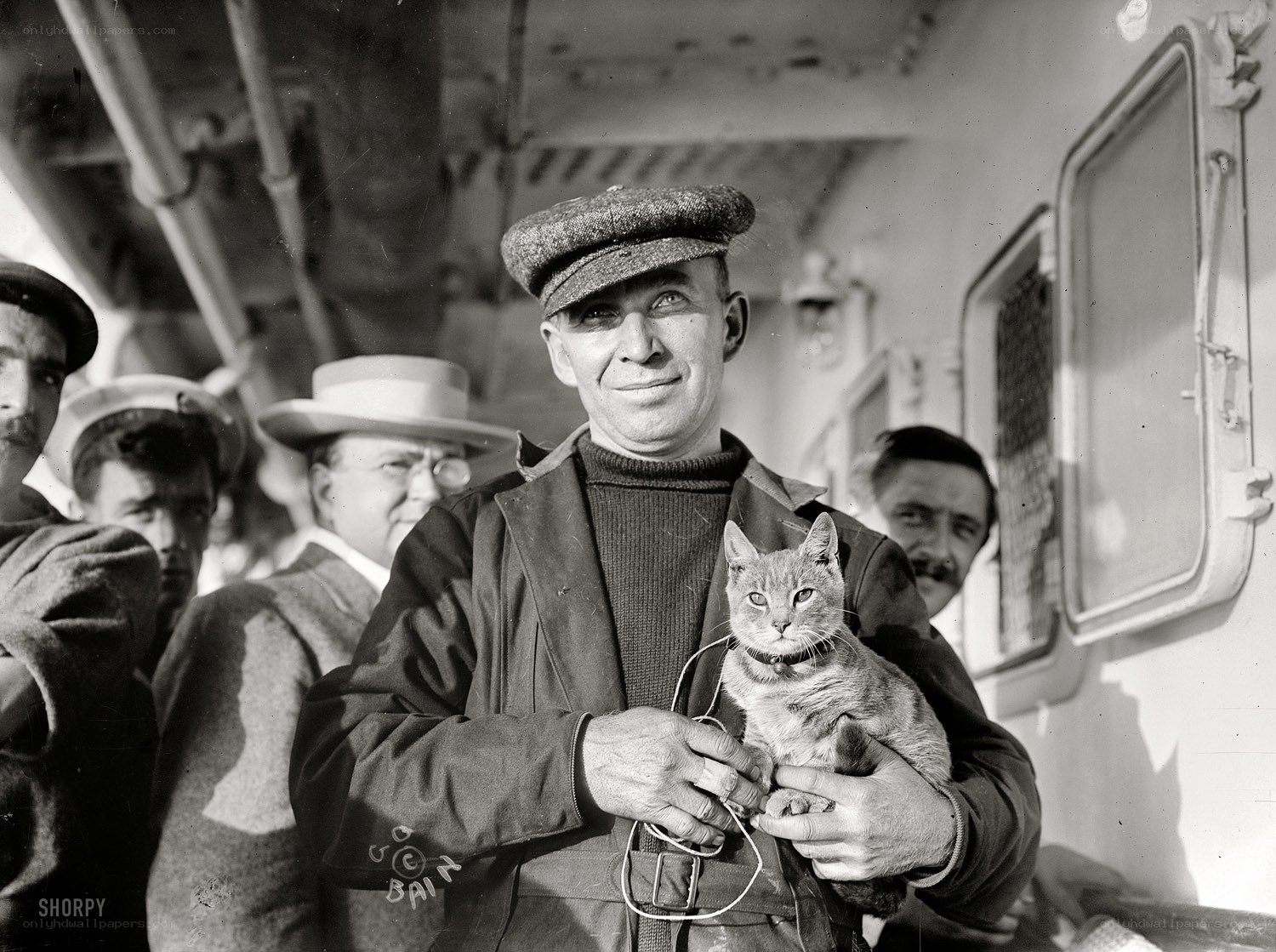 Man holding a cat on a ship