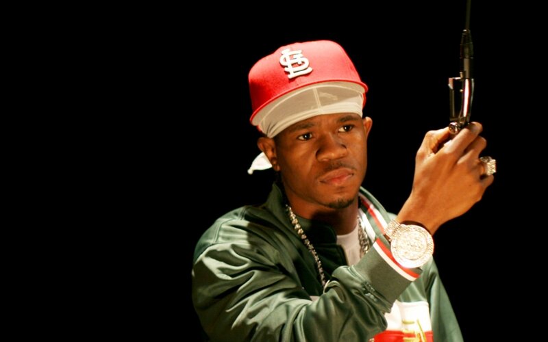 Man Holding a Gun — Black, Dramatic, Photograph, Baseball Cap