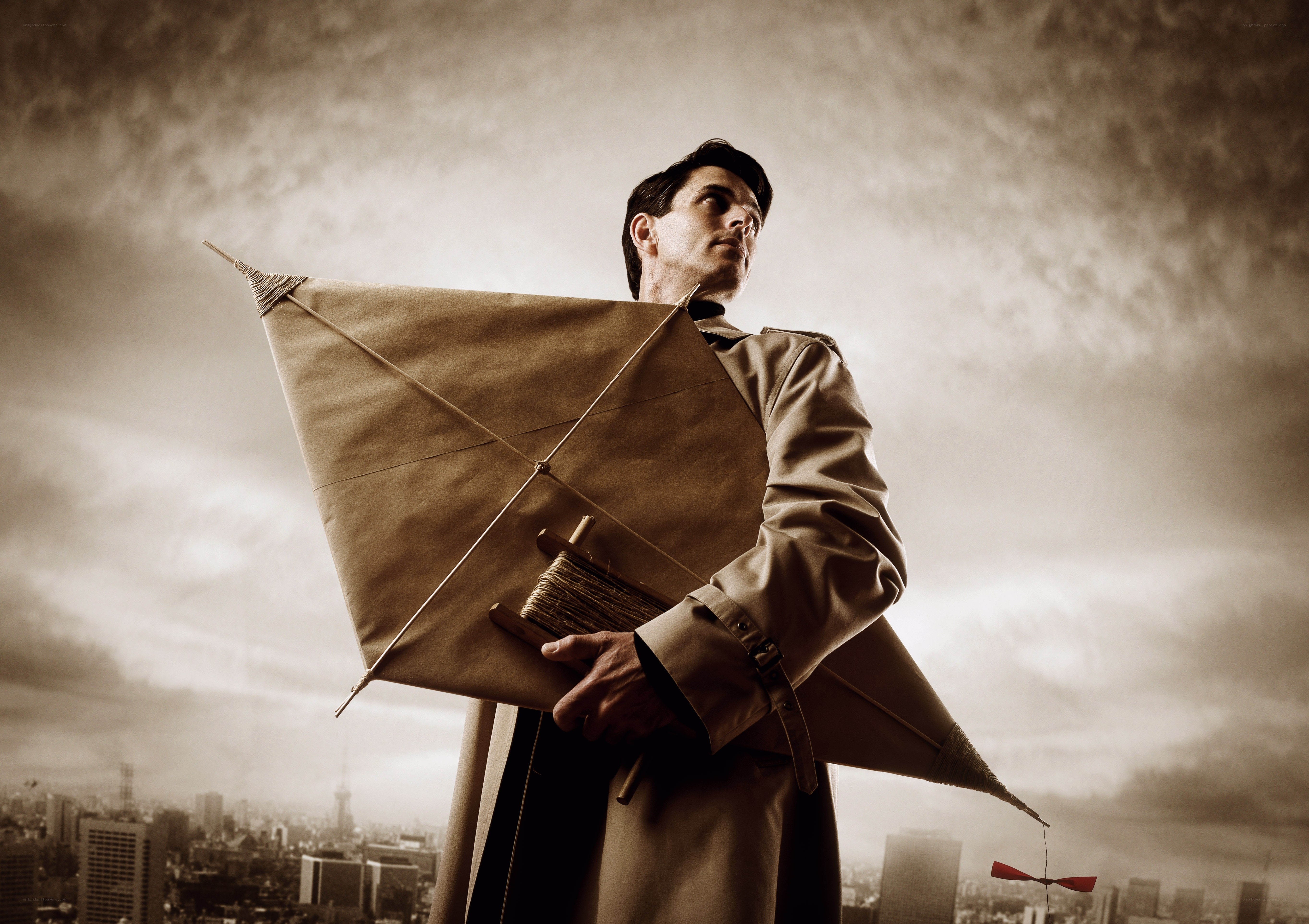 Man holding a kite on a rooftop