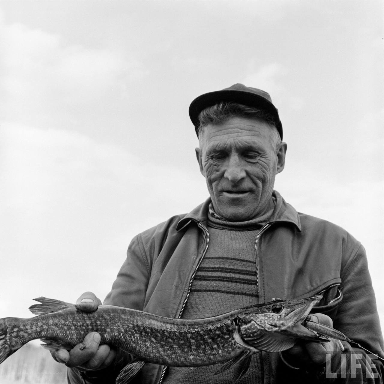 man holding a pike fish