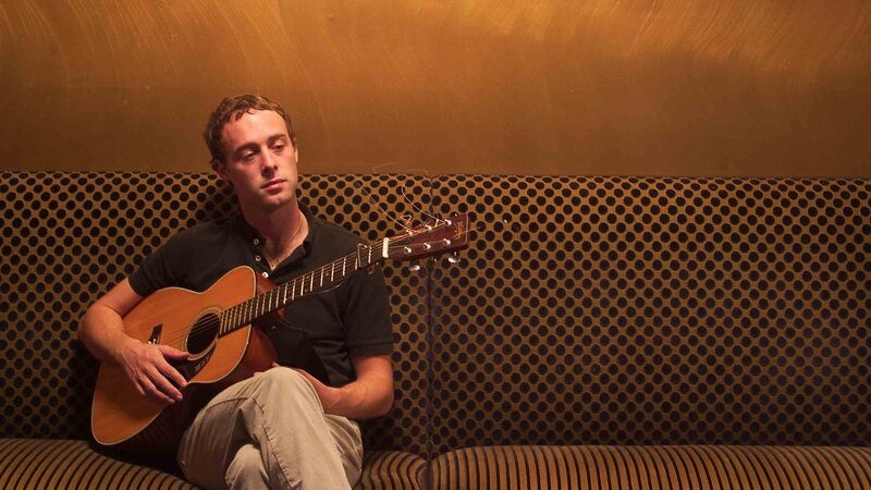 Man Holding Acoustic Guitar — Brown
