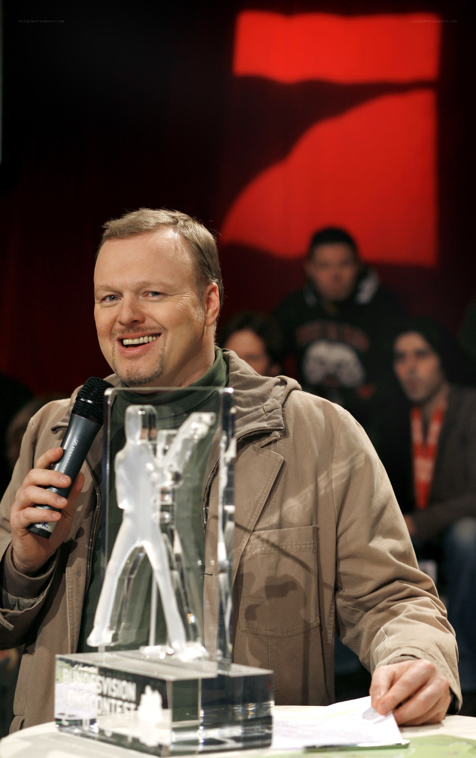 man holding award and microphone