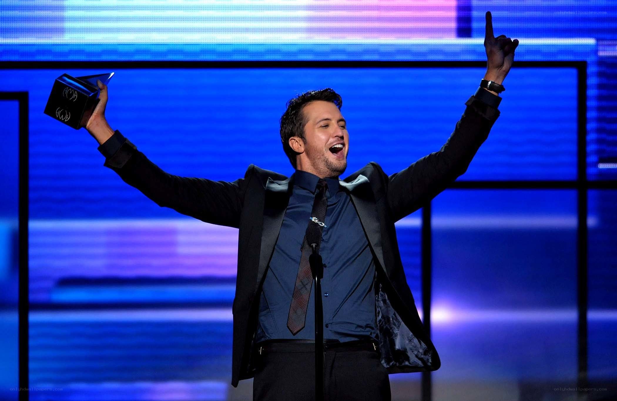 man holding award on stage