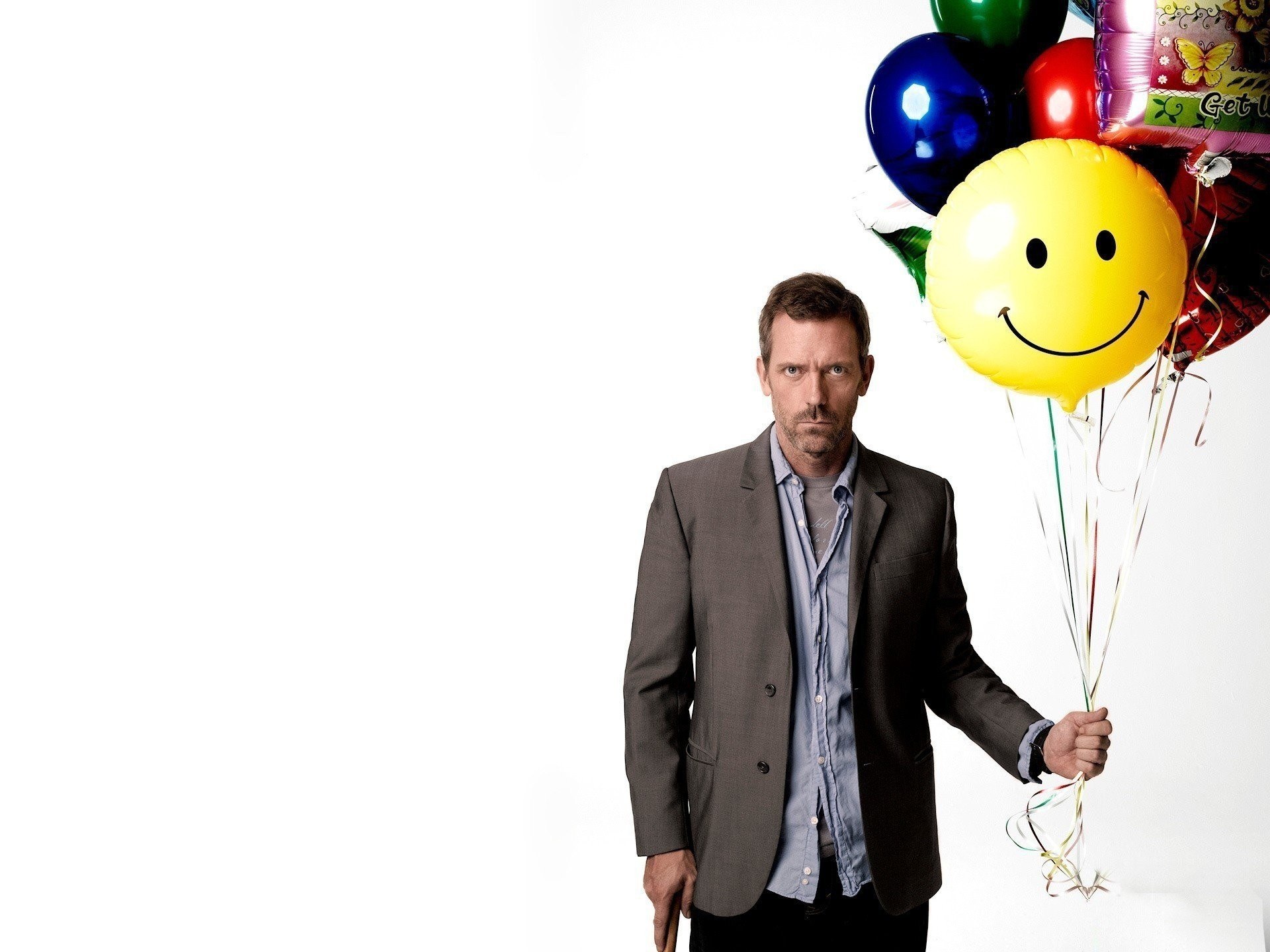 man holding balloons with smiley face