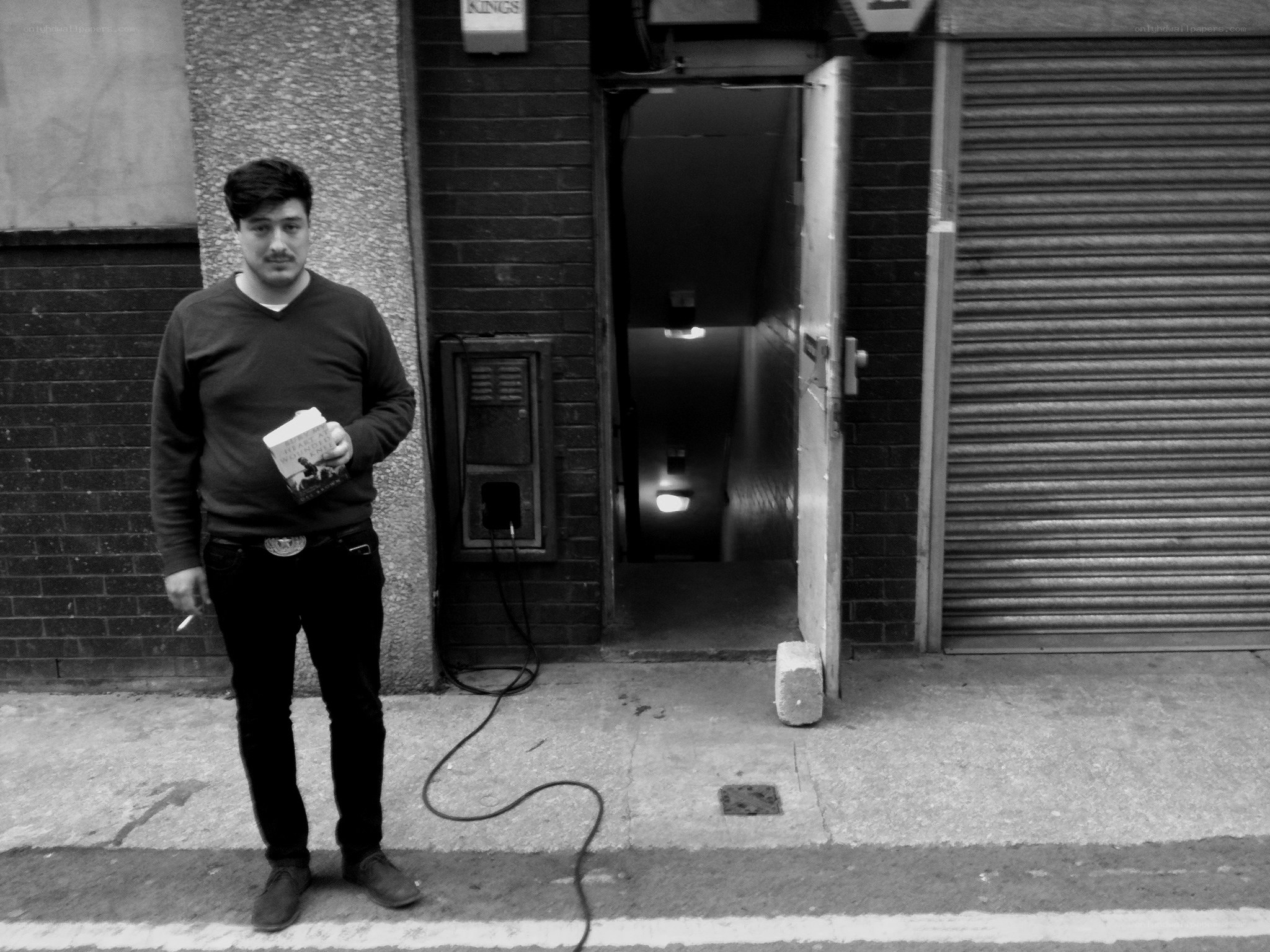 man holding book on street
