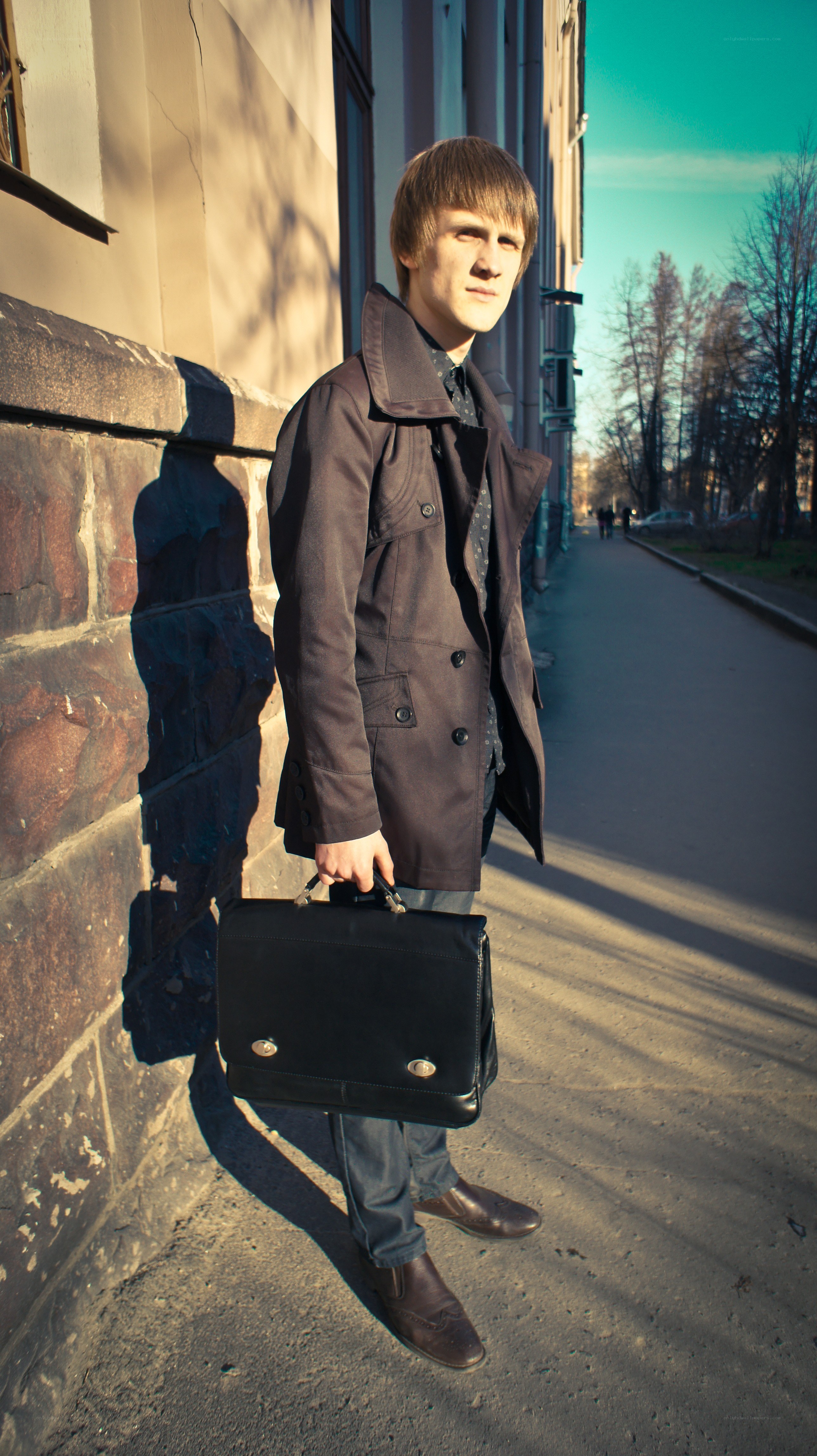 man holding briefcase on street