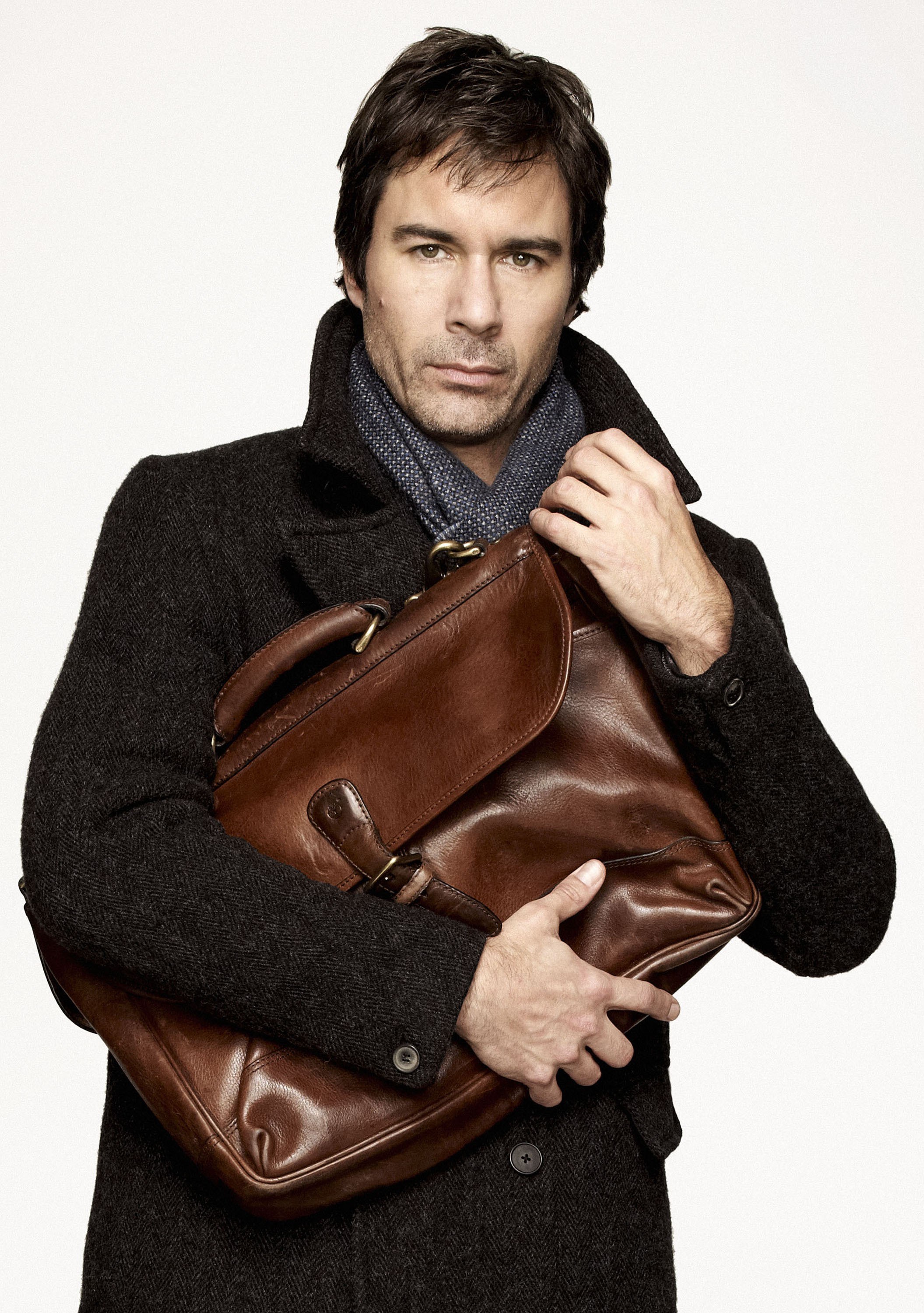 man holding brown leather bag