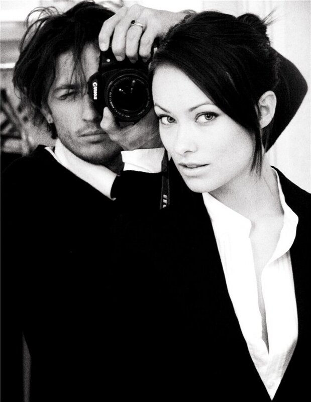 man holding camera behind woman