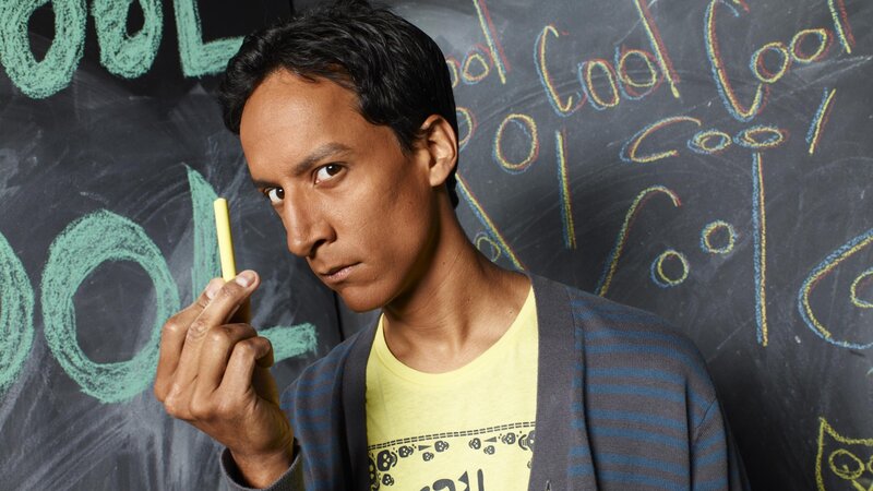 man holding chalk in front of blackboard