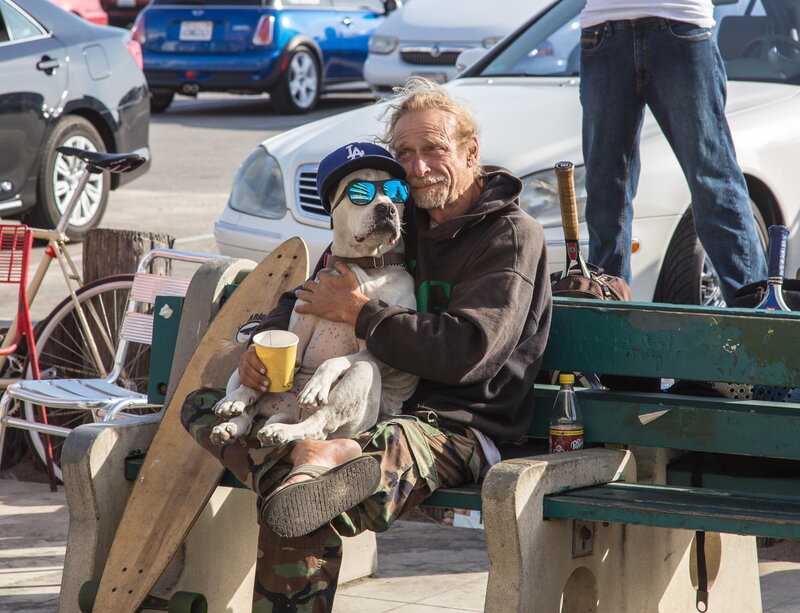 Man Holding Dog on Bench