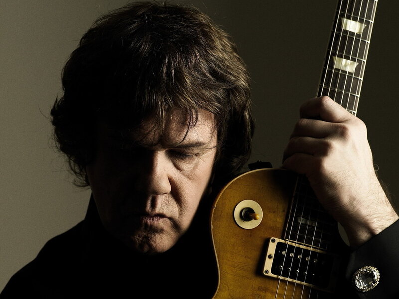 Man Holding Electric Guitar — Brown