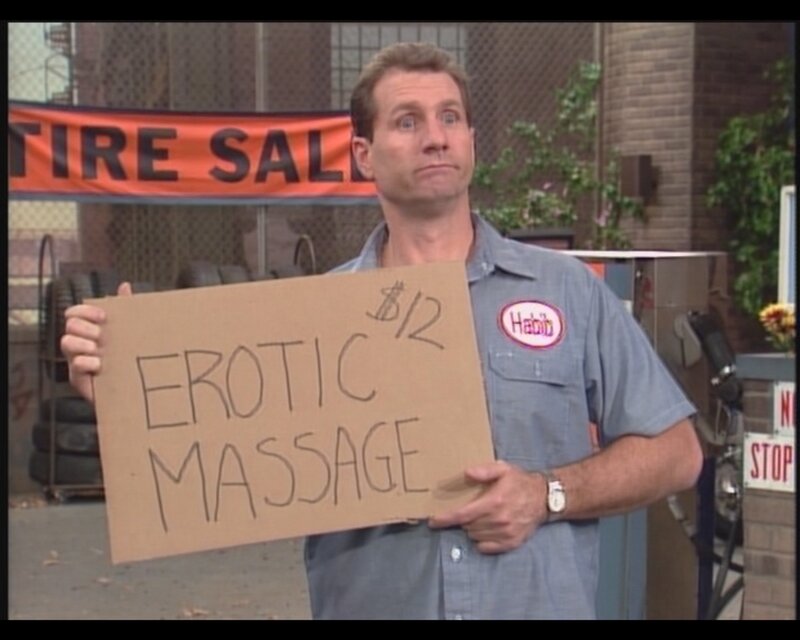 man holding erotic massage sign