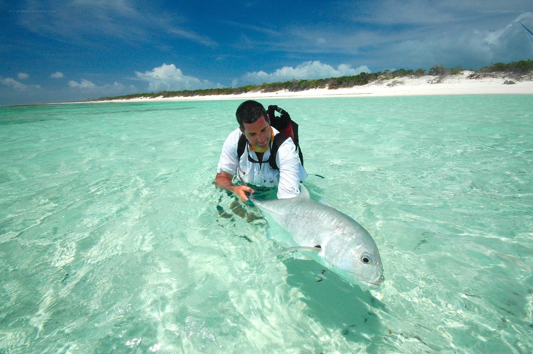 Man holding fish in shallow water