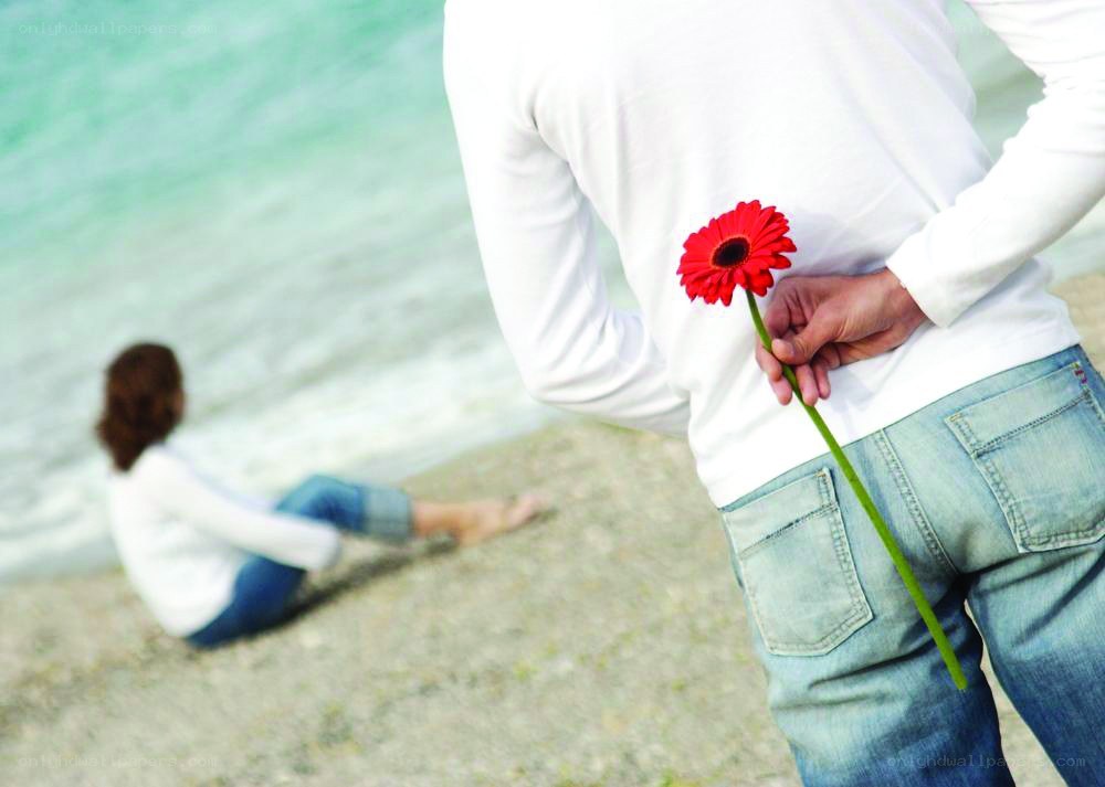 Man holding flower behind back