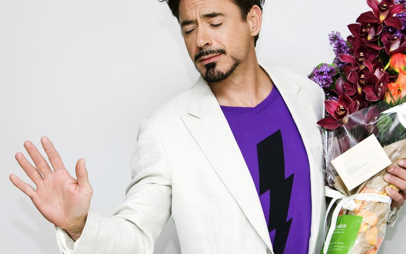 man holding flowers and making a gesture