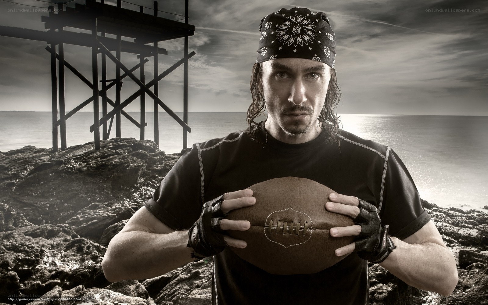 man holding football on beach